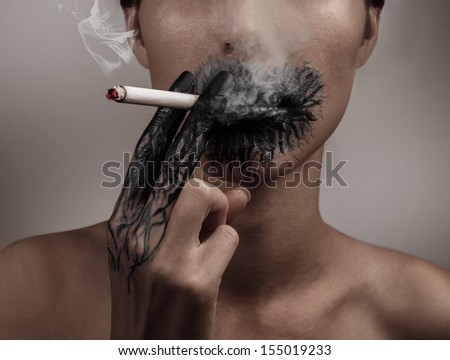 Woman smokes a cigarette, her hand and her mouth blackened, concept of a slow death from smoking