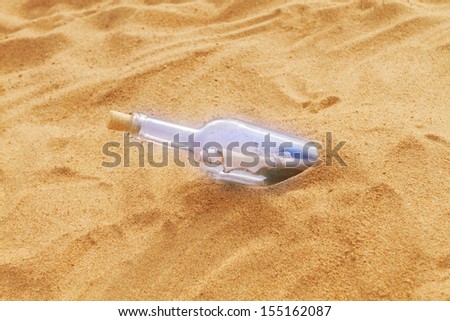 Magic bottle with an old letter in the sand