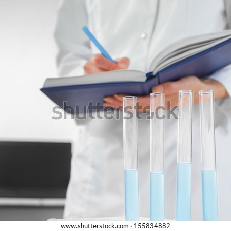 Laboratory technician writes the results of research into the notebook