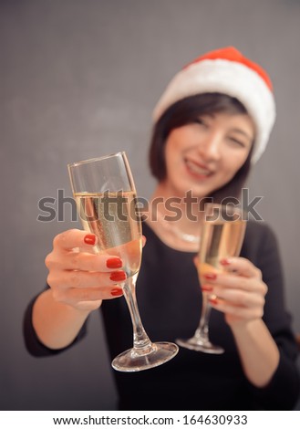 Young happy woman is giving glass with champagne