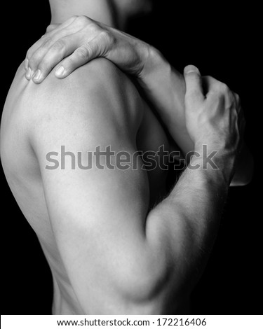 Unrecognizable shirtless man compresses his shoulder, pain in the shoulder