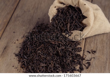 Black leaf tea in the sack on a wooden table