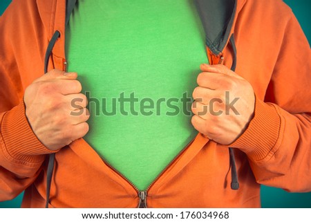 Unrecognizable man opens shirt showing green t-shirt, space for text