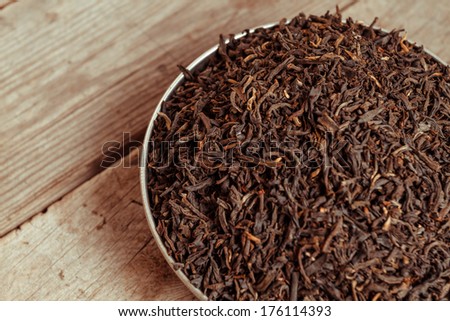 Black leaf tea on a wooden background