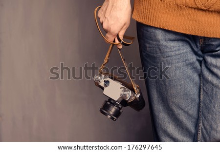 Man holds a retro photo camera, space for text
