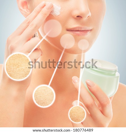 Woman applies moisturizer cream on face, concept of skincare, in circles dry skin before cream