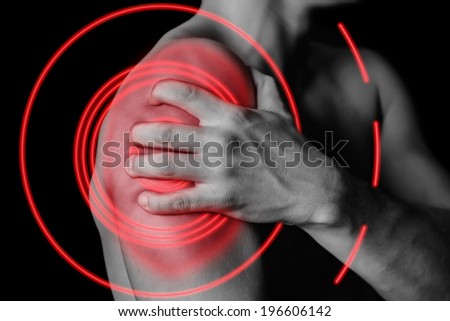 Unrecognizable man compresses his shoulder, pain in the shoulder, side view, pain area of red color