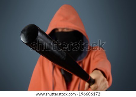 Aggressive man in mask holds baseball bat