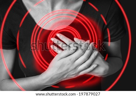 Woman is clutching her chest, acute pain possible heart attack, monochrome image, pain area of red color