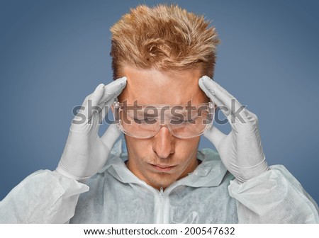 Scientist in protective wear is touching his head, concept of meditation or headache