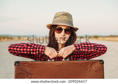 Smiling woman tourist holds vintage suitcase, travel theme