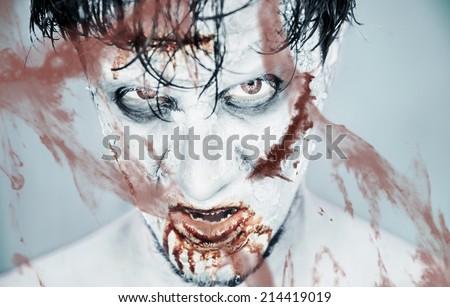 Scary zombie man behind a bloody glass, Halloween or horror theme