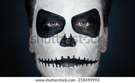 Portrait of serious man with Halloween skull makeup. Halloween or horror theme