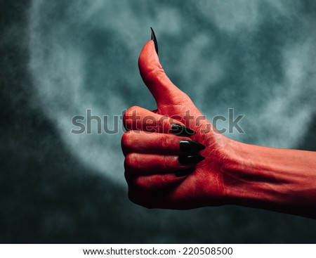 Red demon or devil hand with thumb up gesture on background of full moon. Halloween or horror theme