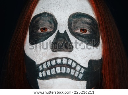 Portrait of spooky skull woman with Halloween makeup and red hair