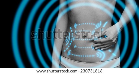 Woman holds a fold of skin on belly, monochrome image. Fat loss and liposuction concept