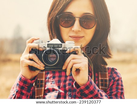 Traveler smiling girl takes photographs with vintage old photo camera on nature