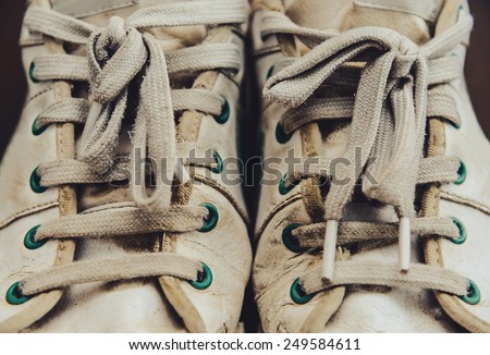 Dirty old white sneakers with shoelaces
