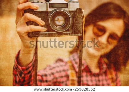 Smiling young woman with retro photo camera, focus on camera. Vintage image