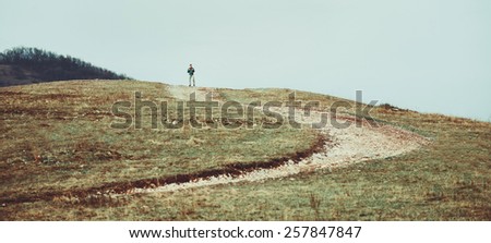 Hiker man walking down on footpath on hill