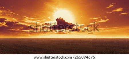 Sunset landscape. Sun sets behind clouds in the evening over meadow in summer