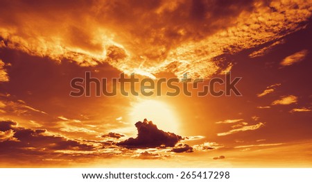 Beautiful sunset. Sun sets behind clouds in the evening