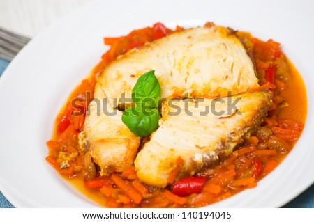 Roasted fish in tomato marinade with carrots and red pepper