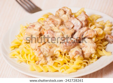 Sliced fried chicken in a creamy sauce. with fusilli pasta