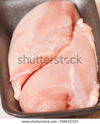 Chicken breast fillets in black food packaging tray