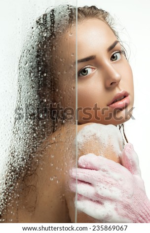 Beautiful girl washing her body shower gel for weeping glass shower door