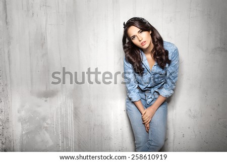 Pretty woman in jeans watchig at camera