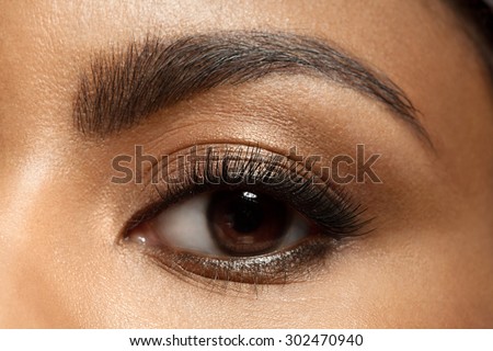 Close-up of make-up eye with long eyelashes and brown eyebrows of black woman