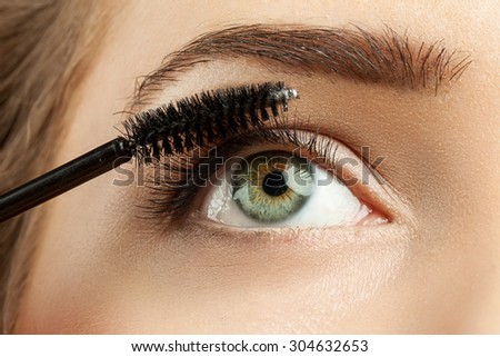 Close-up of make-up green eye with long lashes with black mascara