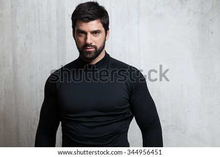 Portrait brutal athlete in sportswear on a cement background