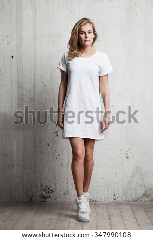 Girl in a white T-shirt against a background of a cement wall