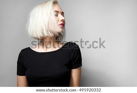 Portrait of a young blonde woman with  red lipstick on her lips in a short black T-shirt