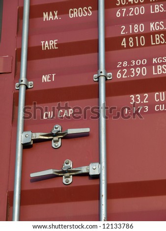 Close-up of outside of red shipping container with handles and standard weight information printed on the outside