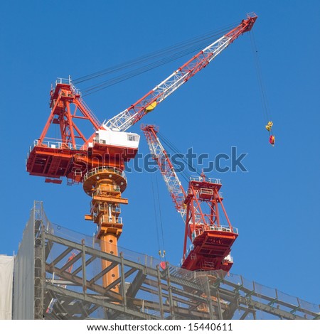 Red and white steel crane at a high rise building site