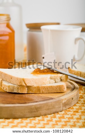 Breakfast of bread and jam on the table knife