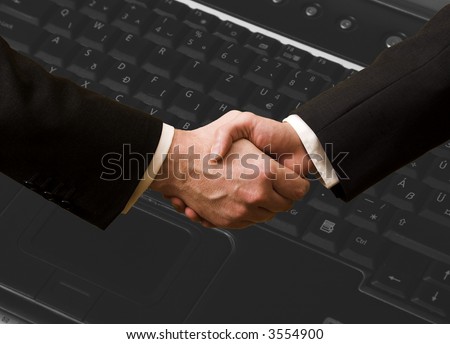 Business handshake with computer, laptop background