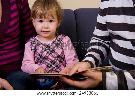 Beautiful child read a book with parents