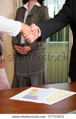 Businessman and woman shaking hands at meeting
