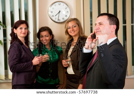 Business man on phone at meeting, women having conversation