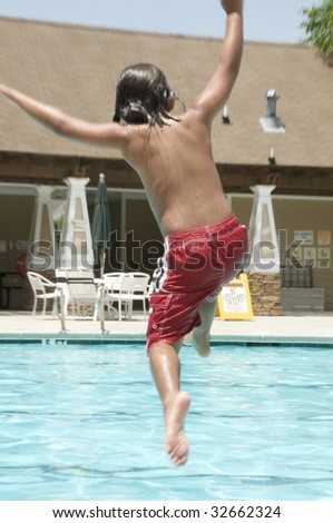 Little boy jumping into pool