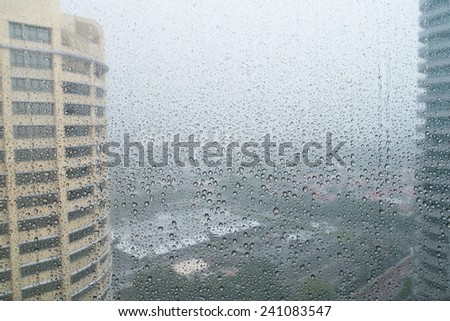 Rain drops in window with cityscape background
