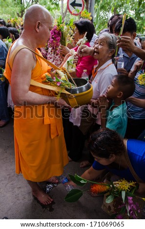 many people give flowers to buddhist monks for alms in the tak bat dok mai (give flowers to monks) at phrabuddhabat temple on July 23,2013 in saraburi,thailand.