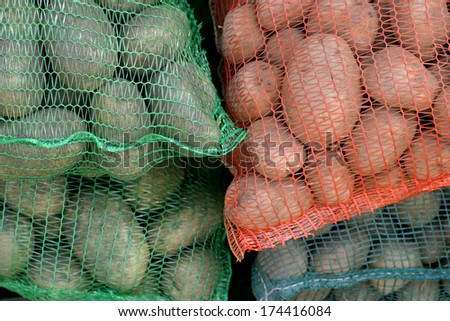 Colorful potato net bags at marketplace.