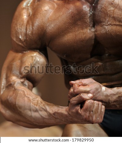 Clenched fists, bodybuilder in contest situation (sharpness on fists).