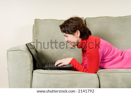 girl on the couch checking email on laptop