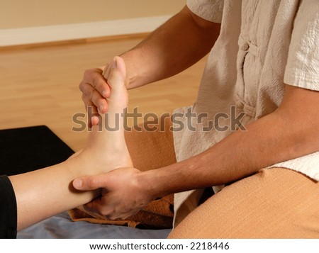 therapist giving a foot massage to client